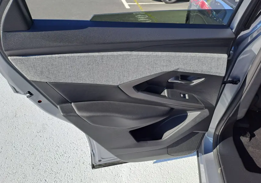 Vue côté gauche de la porte arrière grise Artense du Peugeot 3008 2024 avec garniture tissu gris et commandes électriques.