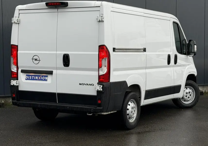 Vue 3/4 arrière droite d’un Opel Movano Fourgon blanc avec portes arrière battantes et porte latérale tôlée.