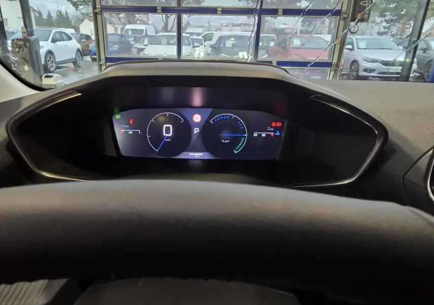 Vue intérieure du combiné numérique du tableau de bord de la Peugeot 208 hybride noire, affichage digital clair.