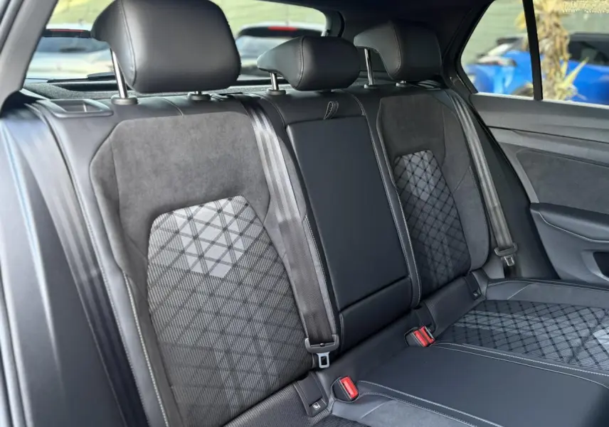 Vue intérieure des sièges arrière en tissu et cuir noir avec motifs géométriques de la Volkswagen Golf VIII R-Line.