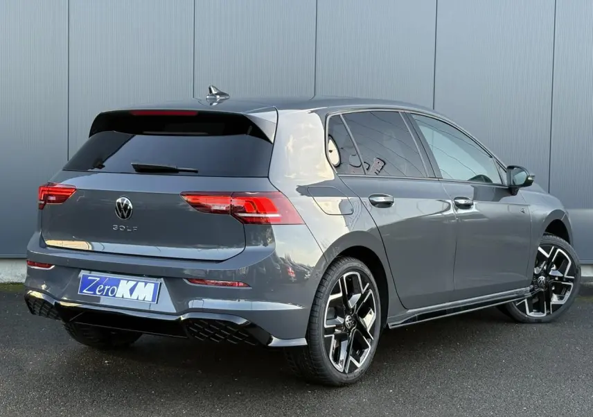 Volkswagen Golf VIII R-Line gris dauphin vue 3/4 arrière droit avec jantes alliage 18 pouces et toit ouvrant panoramique.
