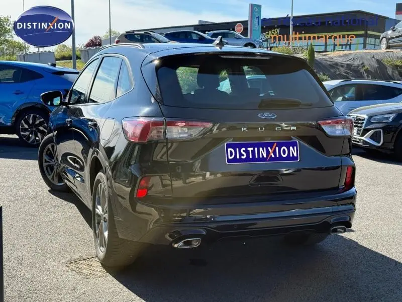 Vue 3/4 arrière droite du Ford Kuga 2.0 EcoBlue noir Agate métallisé avec double sortie d’échappement et barres de toit.