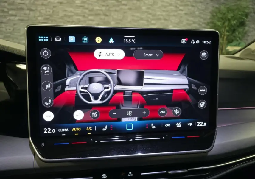 Écran tactile central affichant le tableau de bord digital d'une Volkswagen Golf VIII rouge, vue de face intérieure.