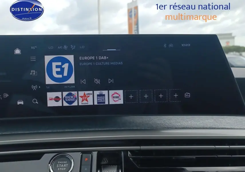 Vue intérieure centrée sur l'écran tactile et la console du Peugeot 3008 gris Artense, version 2025 hybride.