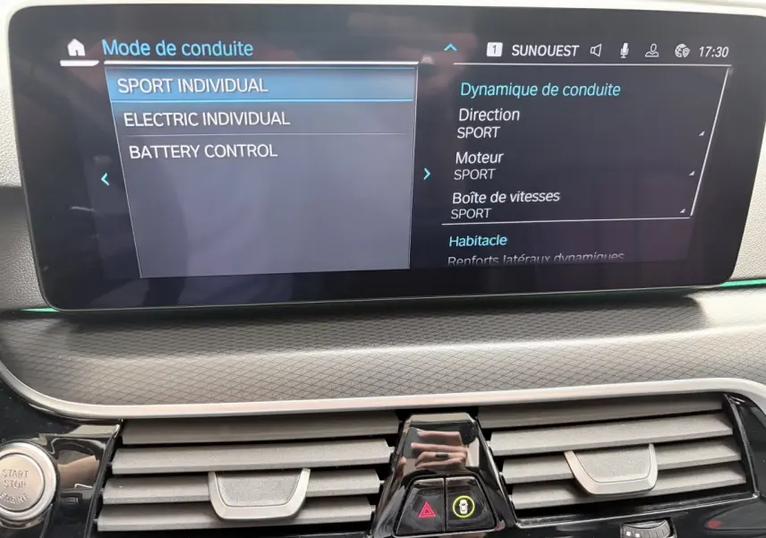 Écran tactile central affichant les modes de conduite dans l’habitacle d’une BMW Série 5 Touring noire.