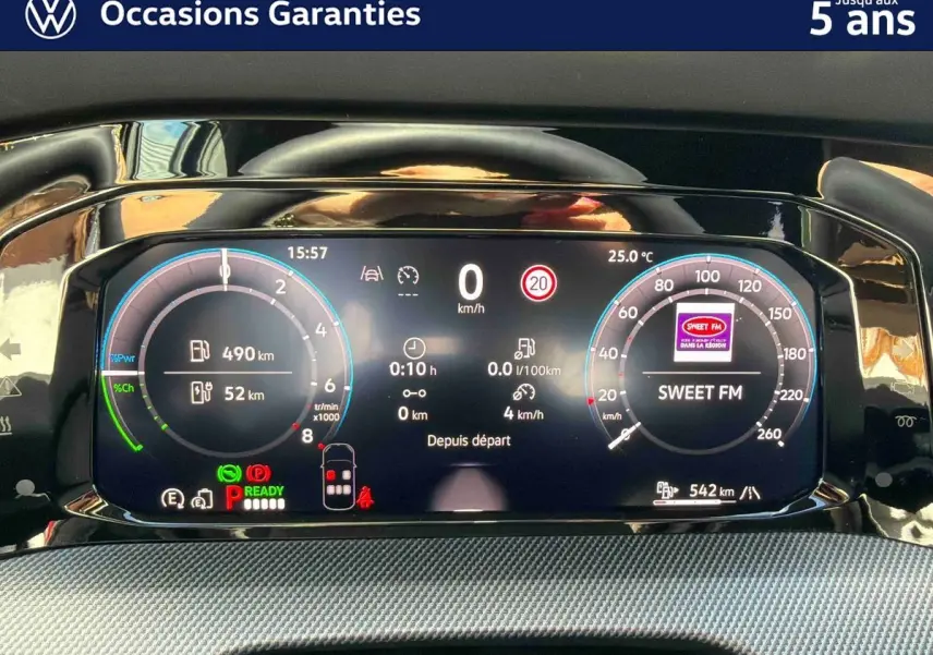 Tableau de bord digital de la Volkswagen Golf 1.5 eHybrid 272 DSG6 2025 affichant vitesse, autonomie et radio Sweet FM.