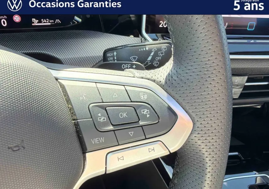 Gros plan sur le volant sport en cuir perforé avec commandes multifonctions du Volkswagen Golf 1.5 eHybrid 2025.