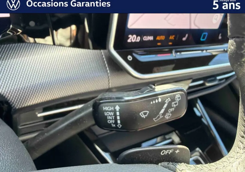 Gros plan sur la commande d’essuie-glace à gauche du volant dans l’habitacle d’une Volkswagen Golf bleue 2025.