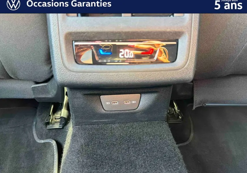 Panneau de commande de climatisation arrière et deux ports USB-C dans l'habitacle d'une Volkswagen Golf bleue.