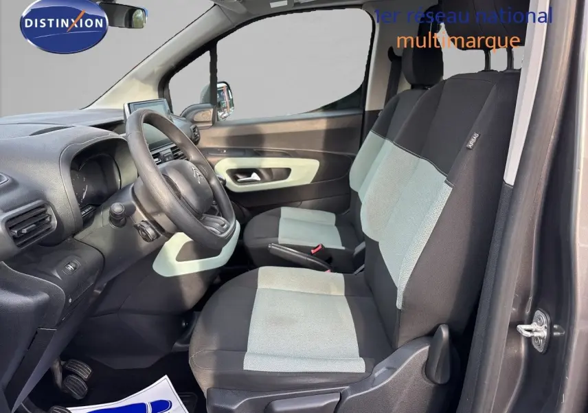 Vue intérieure côté conducteur du Citroën Berlingo Multispace gris platinium, sièges bicolores noirs et gris avec volant visible.