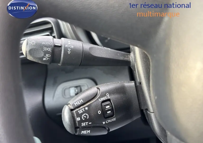 Gros plan sur les commandes au volant du Citroën Berlingo Multispace gris platinium, montrant les leviers de clignotants et régulateur de vitesse.