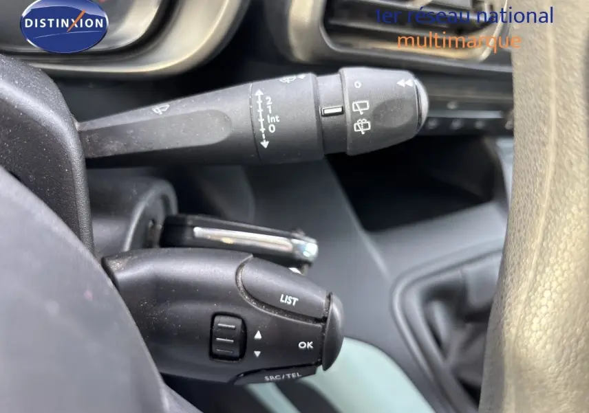 Gros plan sur les commandes au volant du Citroën Berlingo Multispace gris platinium, montrant les boutons LIST et OK.