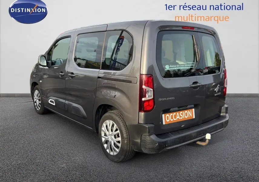 Vue 3/4 arrière droite d'un Citroën Berlingo Multispace gris platinium avec attelage, sur fond neutre.