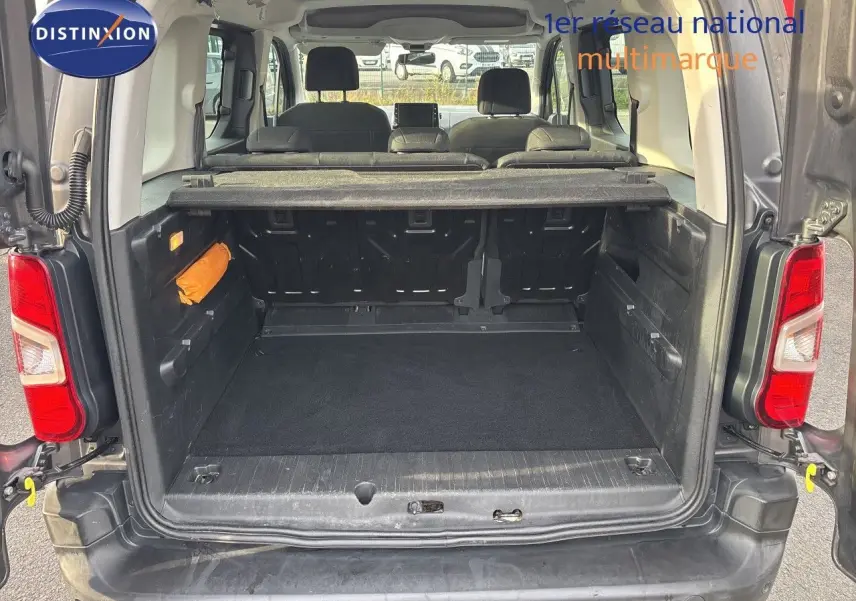 Vue arrière du coffre ouvert d’un Citroën Berlingo Multispace gris platinium, montrant l’espace de chargement et les sièges arrière.