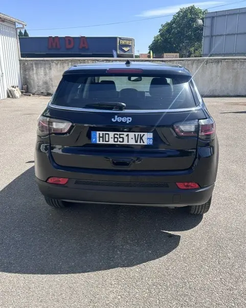 Vue arrière d'un Jeep Compass noir 2025, mettant en valeur ses feux arrière et la plaque d'immatriculation française.