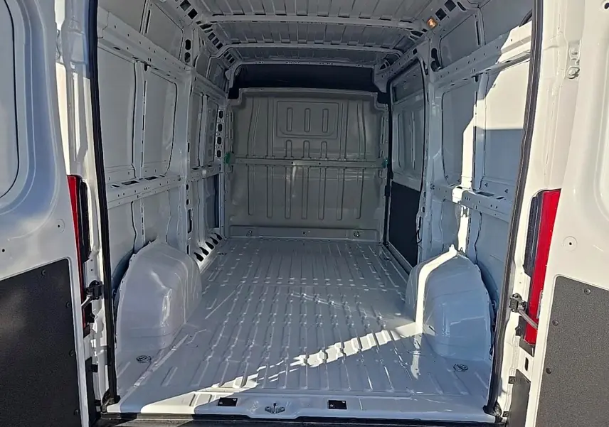 Vue intérieure arrière du Peugeot Boxer Fourgon blanc L2H2 2026, montrant l’espace de chargement vide et la cloison pleine.