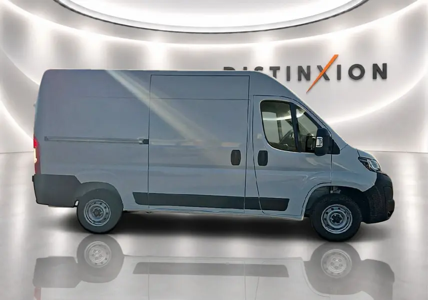 Vue de profil côté gauche d’un Peugeot Boxer Fourgon blanc, avec porte latérale coulissante et jantes acier.