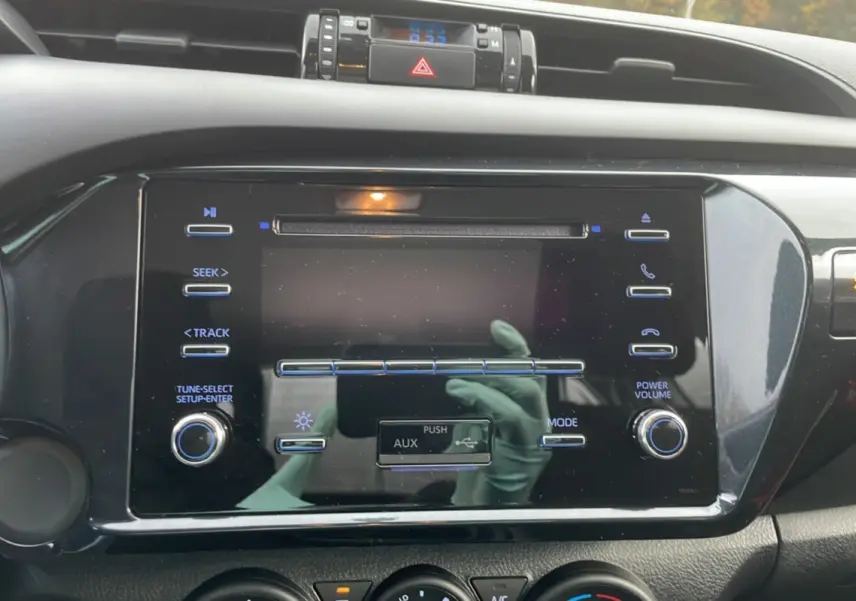 Vue rapprochée de la console centrale du Toyota Hilux 4x4 2024, mettant en valeur l'écran tactile et les commandes audio.