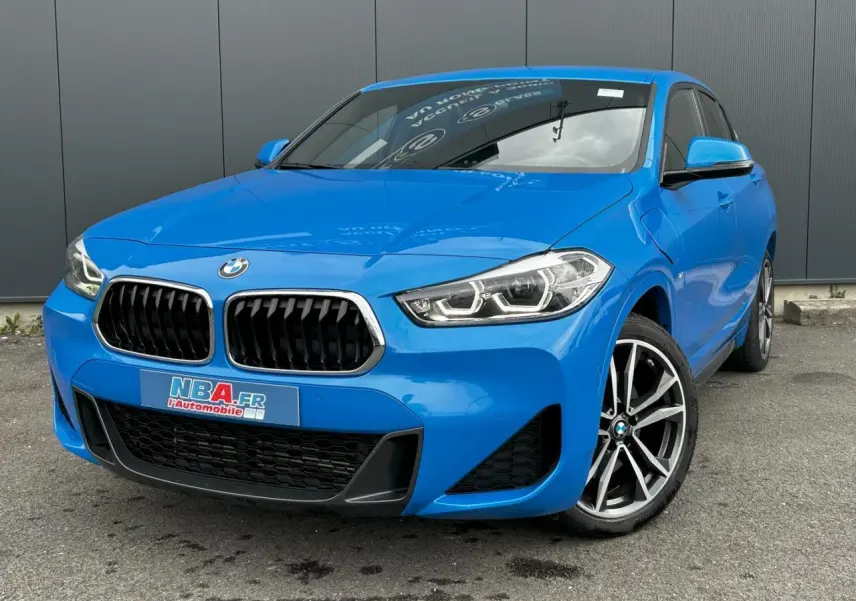 BMW X2 bleu Misano en vue 3/4 avant droit, avec calandre noire et jantes alliage bicolores 19 pouces.