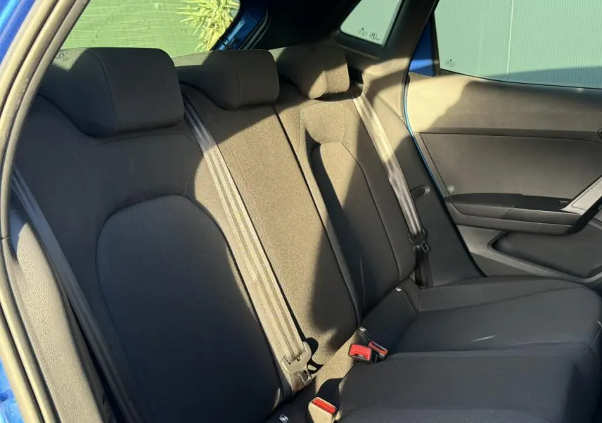 Vue intérieure sur la banquette arrière noire du SEAT IBIZA bleu saphir, avec ceintures et appuie-têtes visibles.