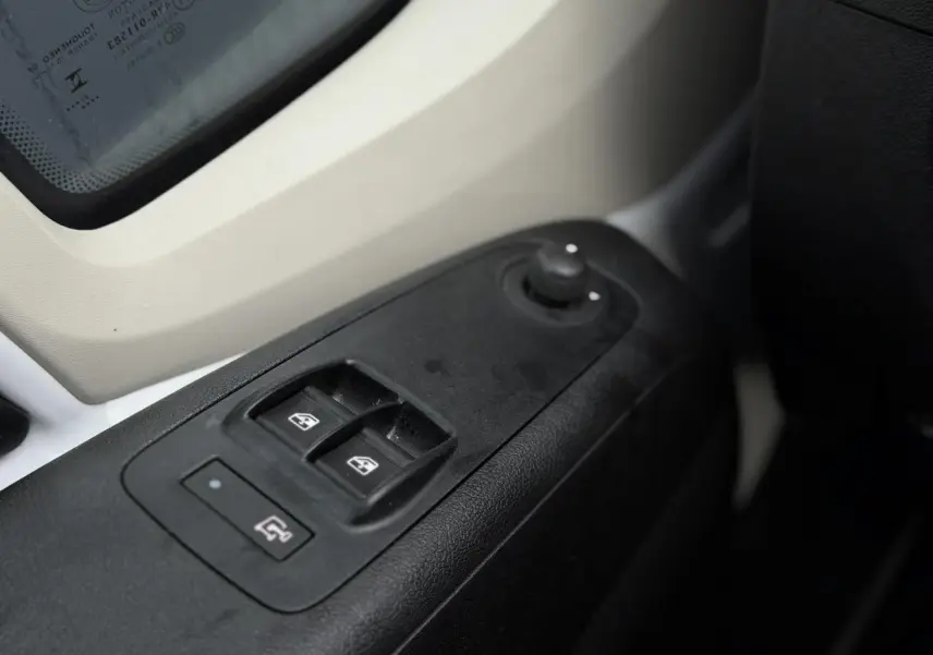 Gros plan sur les commandes de lève-vitres et rétroviseurs côté conducteur du fourgon blanc Opel Movano 2024.