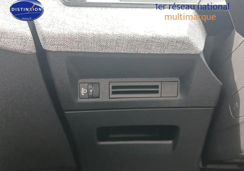 Détail de la console côté gauche avec commande de réglage des phares et tissu gris sur PEUGEOT 5008 bleu, vue intérieure.