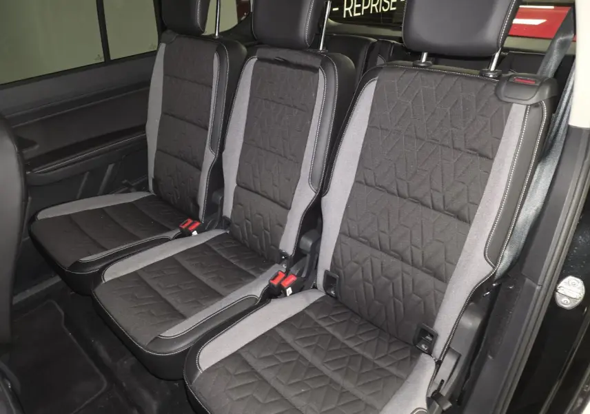 Vue intérieure des trois sièges individuels de la deuxième rangée du Volkswagen Touran noir, avec sellerie tissu Lasano noire et grise.