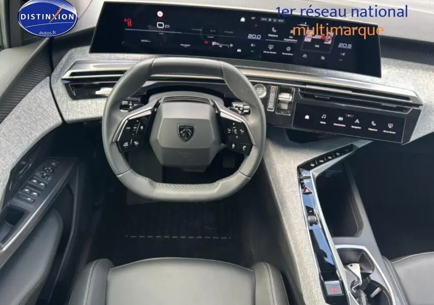 Vue intérieure avant du Peugeot 3008 2025, tableau de bord moderne gris clair avec volant cuir multifonction noir.