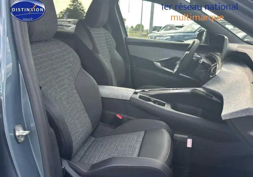Intérieur avant droit du Peugeot 3008 bleu 2025, sièges tissu et cuir avec accoudoir central et tableau de bord moderne.
