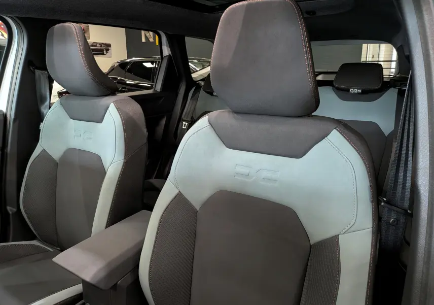 Vue intérieure rapprochée des sièges avant en tissu bi-ton gris et noir du Dacia Bigster Mild Hybrid 2026.