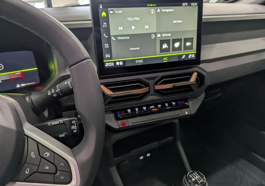 Vue intérieure du tableau de bord du Dacia Bigster 2026, avec écran tactile central et volant partiel en cuir noir.