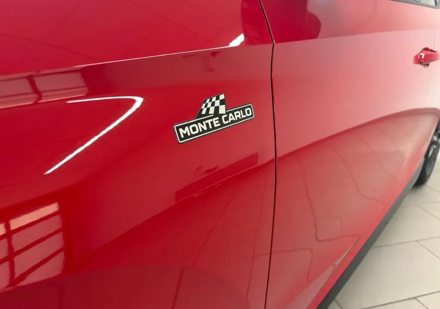 Gros plan sur le côté gauche rouge velvet d'une Skoda Fabia Monte Carlo avec logo distinctif noir et blanc.
