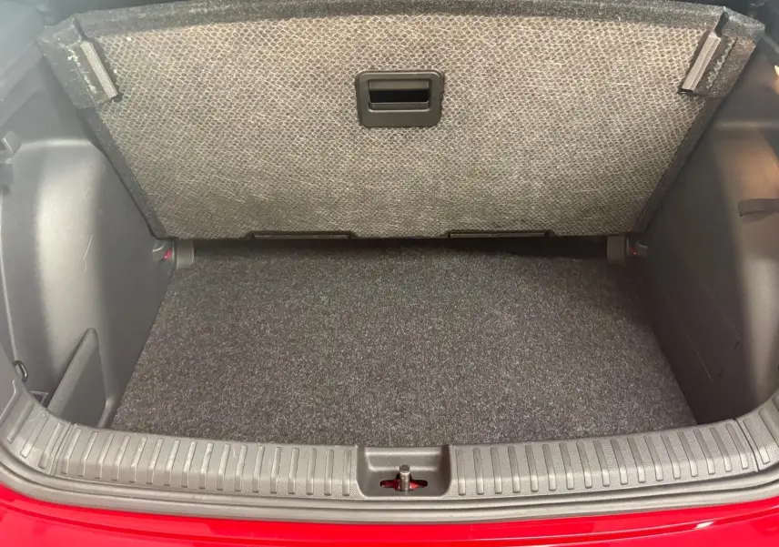 Coffre ouvert de la Skoda Fabia 2025 rouge Velvet avec double plancher variable visible au-dessus du tapis gris.