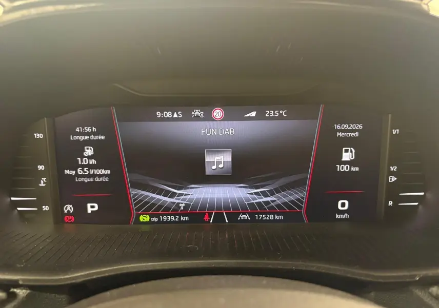 Tableau de bord numérique de Skoda Fabia 1.0 TSI 116 DSG7 Monte Carlo affichant la consommation et la radio, vue de face.