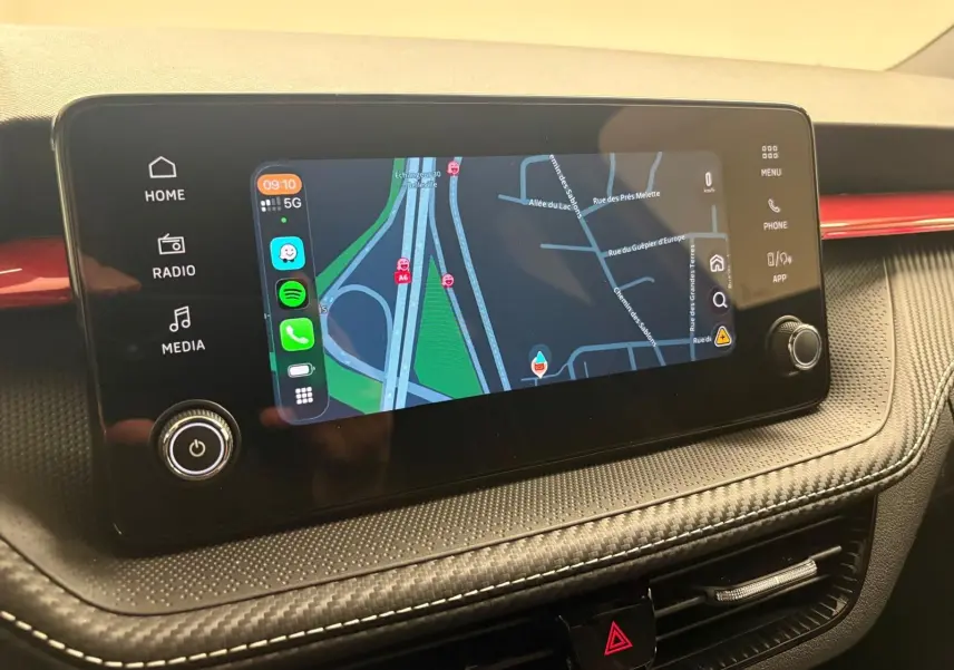Écran tactile central affichant la navigation, sur tableau de bord noir avec insert rouge dans une Skoda Fabia Monte Carlo 2025.