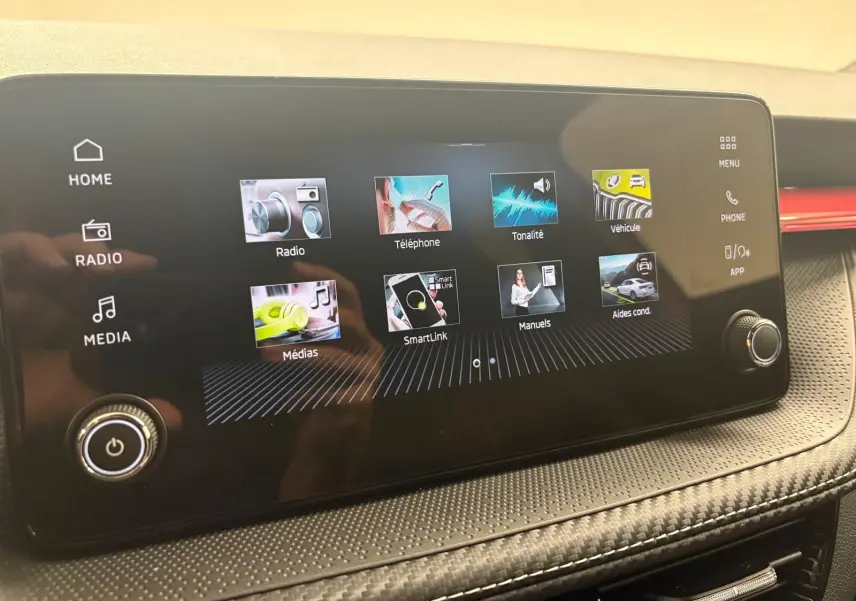 Écran tactile central du tableau de bord de la Skoda Fabia 2025, affichant les menus multimédia et assistance.