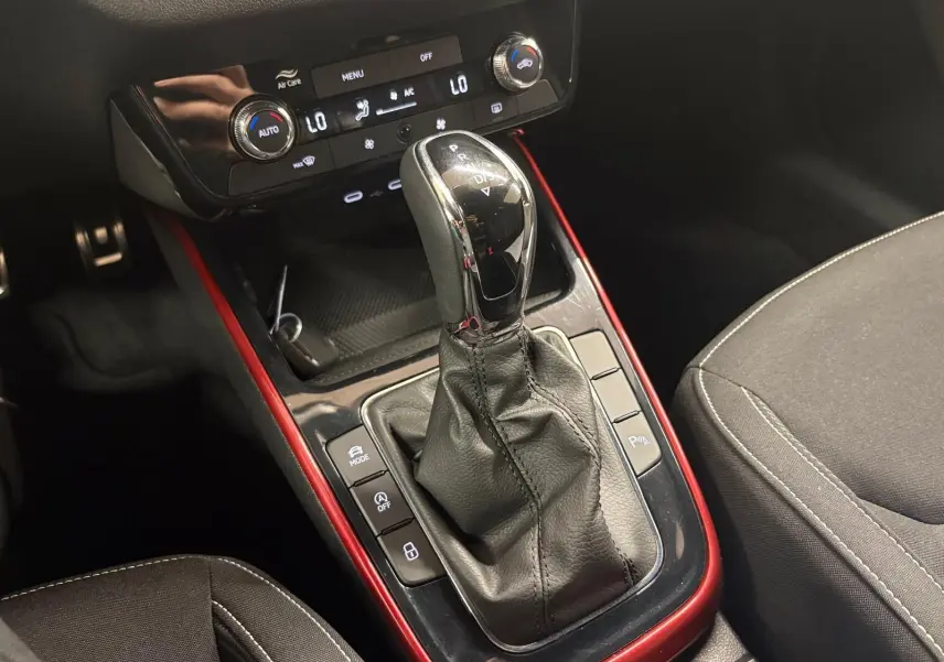 Gros plan sur la console centrale de la Skoda Fabia 2025, levier de boîte auto entouré d’un cadre rouge Velvet.