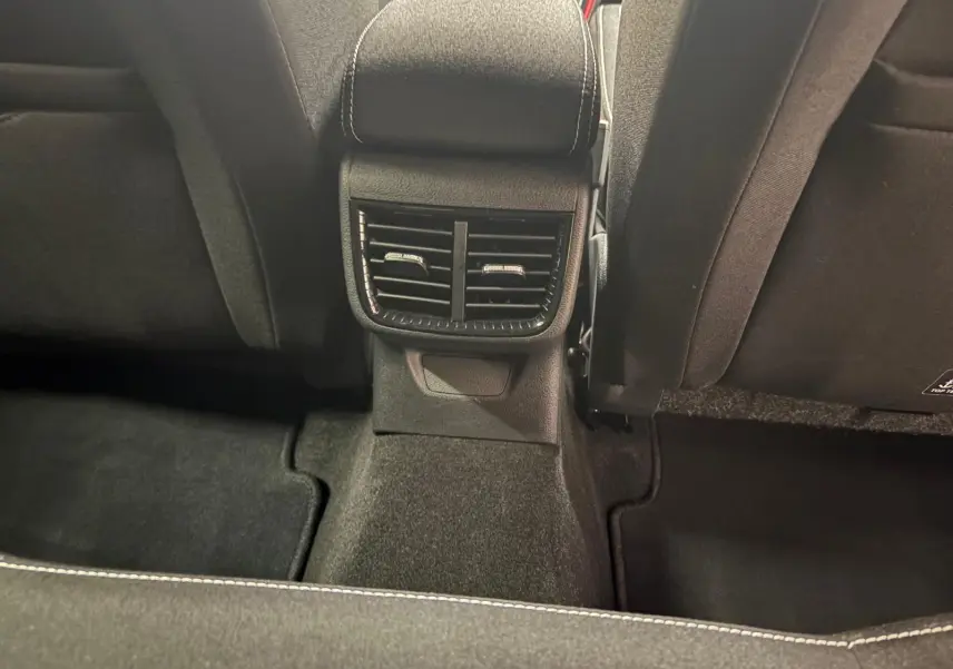 Vue rapprochée des aérateurs arrière et du tunnel central noir avec surpiqûres blanches dans une Skoda Fabia Monte Carlo 2025.