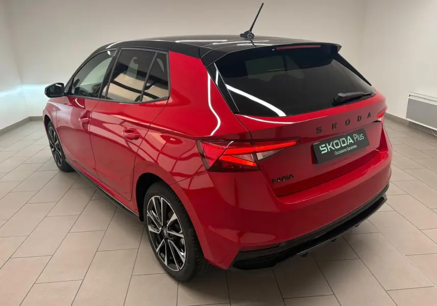 Vue 3/4 arrière droite d'une Skoda Fabia 2025 rouge velvet avec toit noir et jantes alliage noires.