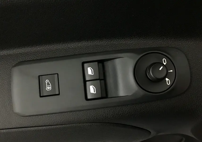 Gros plan sur les commandes de réglage des rétroviseurs et des vitres électriques dans un Peugeot Partner blanc 2025.