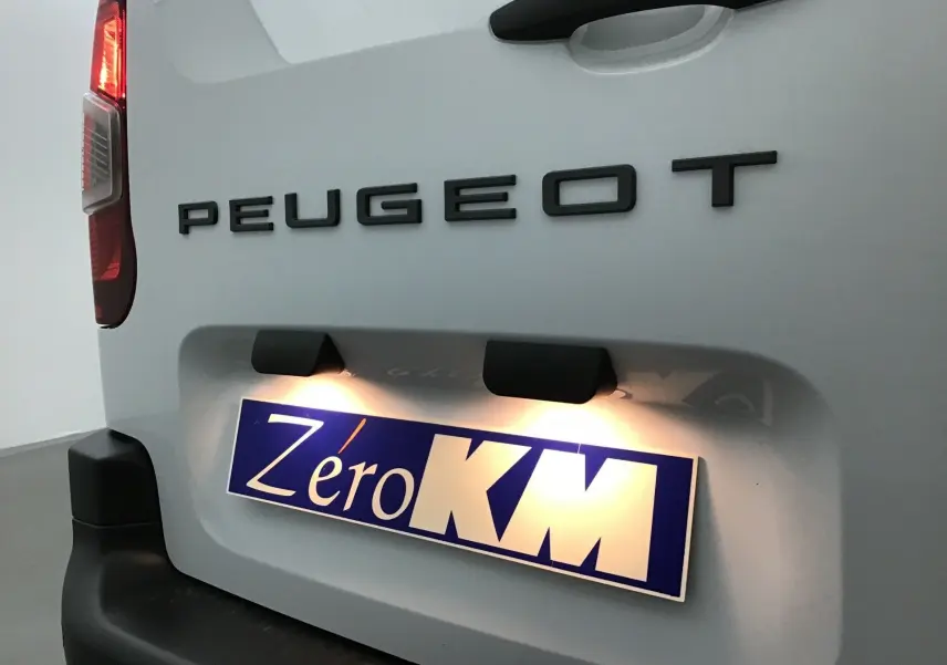 Vue rapprochée arrière gauche du Peugeot Partner blanc 2025 avec logo et plaque d’immatriculation éclairée Zéro KM.