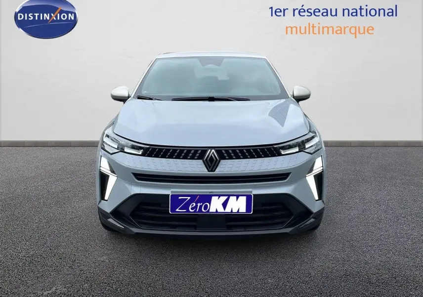 Vue frontale du Renault Captur 1.6 E-TECH hybride 2025 en gris Rafale métal avec éclairage LED distinctif allumé.