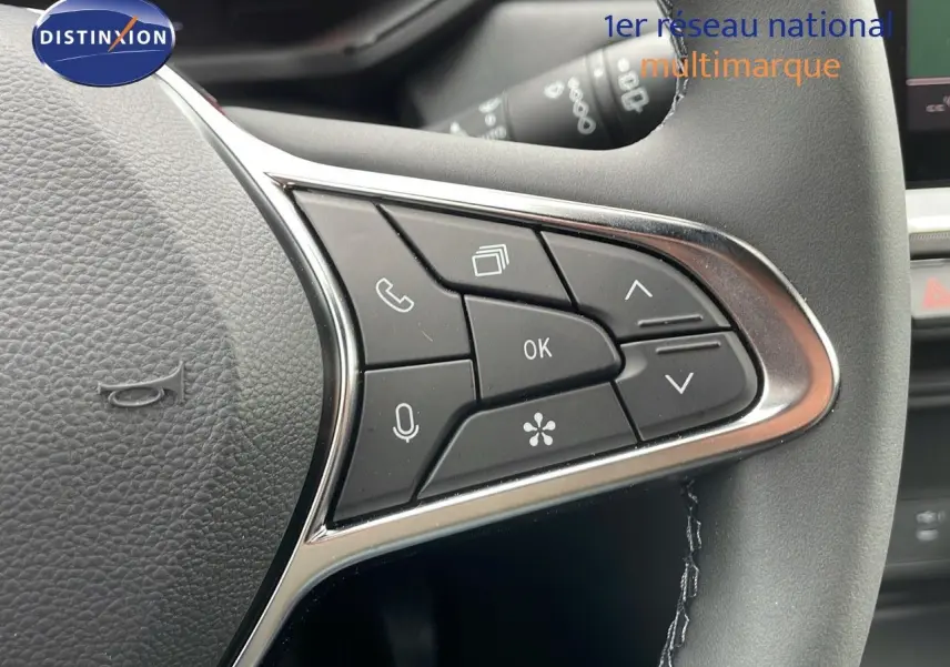 Gros plan sur les commandes multifonctions à droite du volant du Renault Captur gris Rafale métal avec toit beige.