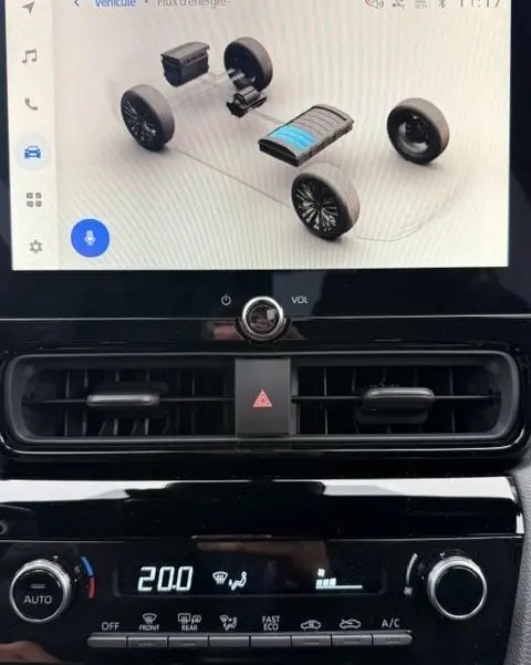 Écran tactile intérieur affichant le flux d'énergie hybride de la Toyota Yaris Cross 2026, avec commandes climatisation en dessous.