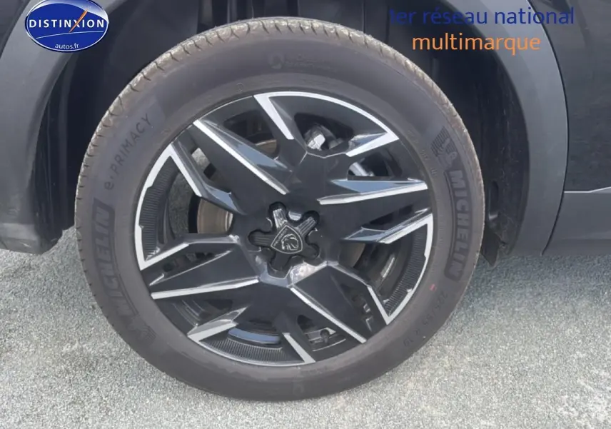 Gros plan sur la jante alu noire et argentée d’un Peugeot 5008 Hybrid 145 allure e-dcs6 noir, roue avant droite.