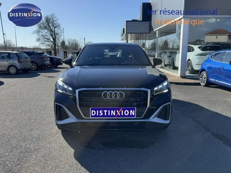 Audi Q2 30 TDI S line noir Mythic métallisé vue de face avec calandre hexagonale et phares LED allumés.