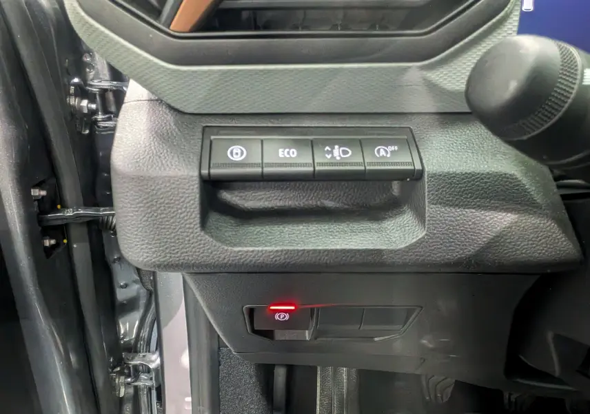 Vue intérieure côté gauche du tableau de bord gris schiste du Dacia Bigster 2026, avec commandes ECO et frein à main électronique.