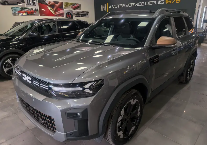 Vue 3/4 avant droite du Dacia Bigster gris schiste avec rétroviseurs couleur bronze et jantes noires en concession.