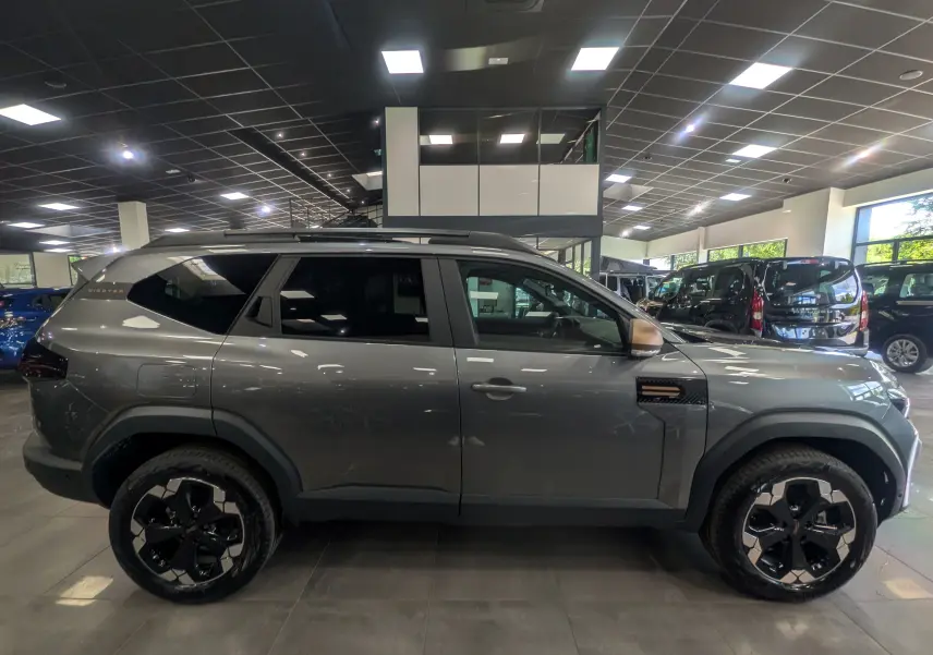 Profil droit du Dacia Bigster gris schiste 2026 en version Mild Hybrid, avec jantes noires et toit noir contrasté.