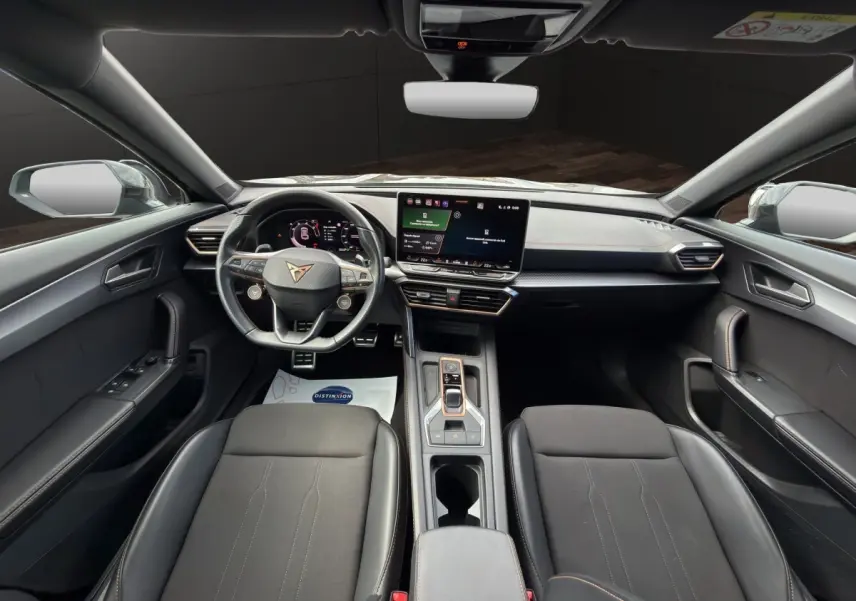 Vue intérieure avant du CUPRA Formentor 2025 avec tableau de bord noir, écran tactile central et volant cuir alu.